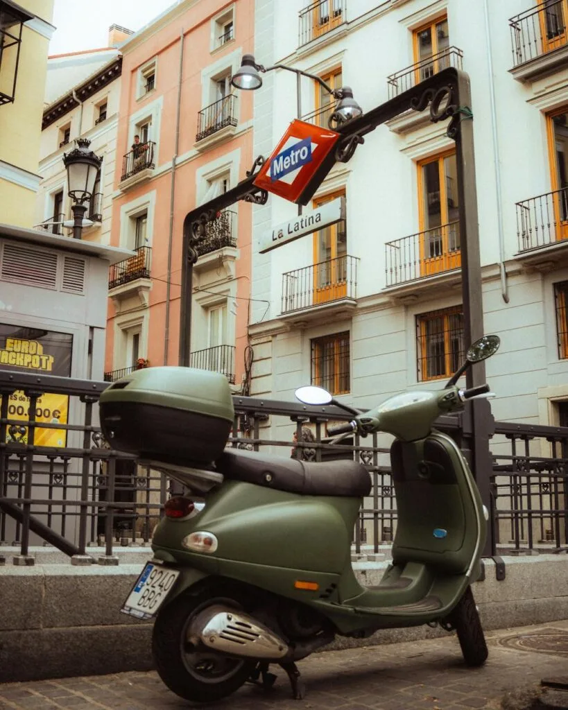 pexels-photo-27255869-27255869-1 Vintage scooter parked near La Latina Metro station in Madrid, Spain, showcasing urban architecture.